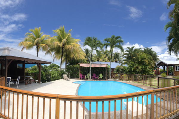 The secured pool area with a carbet, a pergola and a relaxation area in the Lamateliane hiring