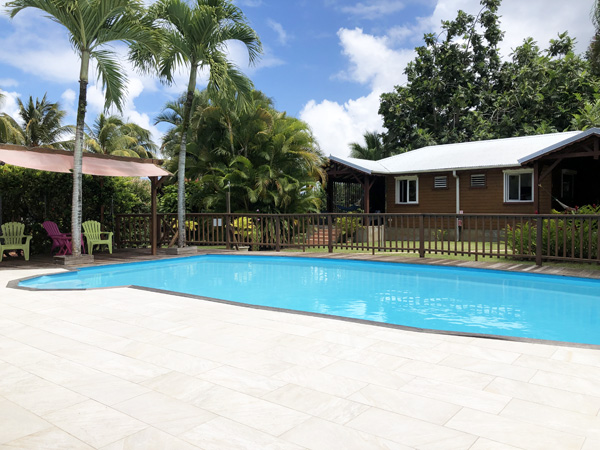 Facing the lodgings, the secured swimming pool and the deck