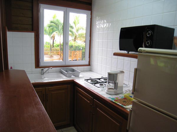 The kitchen of your cottage with a windows in front of the garden